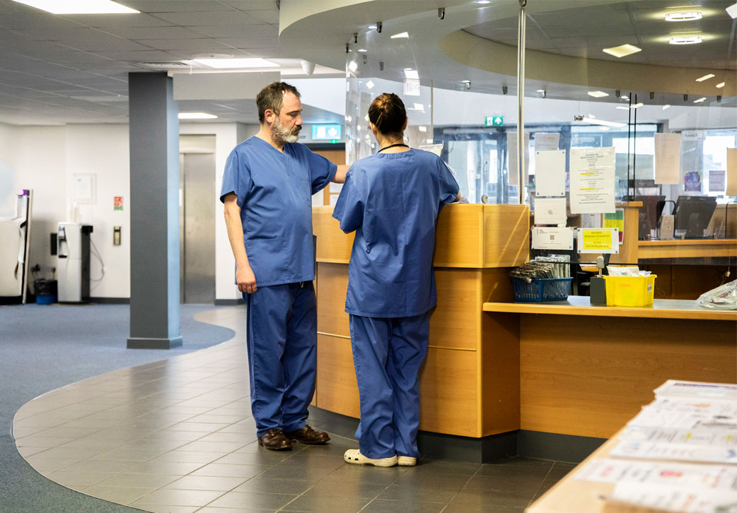 healthcare-workers-conversing-at-a-hospital-recept-mobile