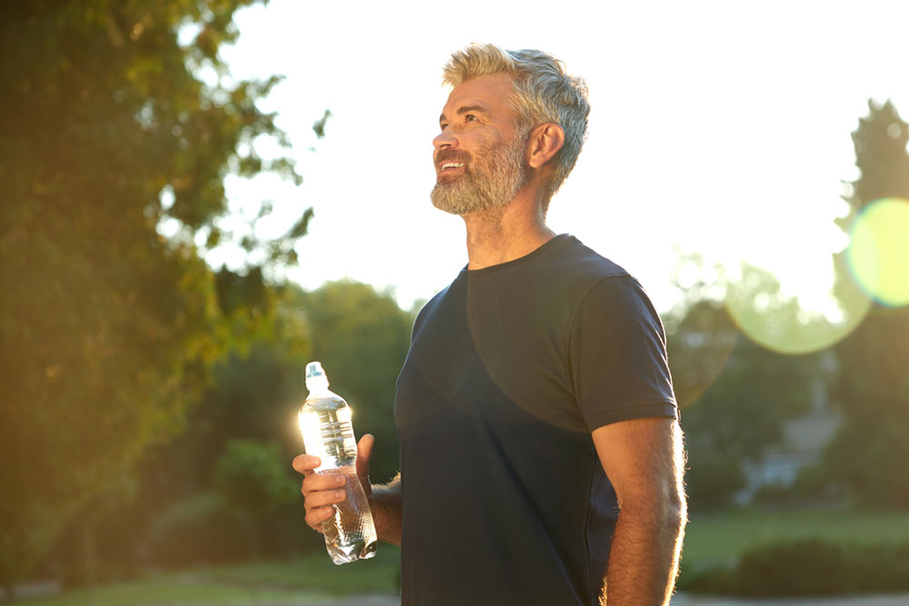 a-man-holding-a-water-bottle-in-a-sunny-park-while-2025-03-26-08-18-40-utc