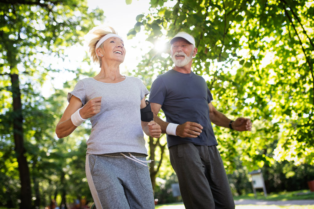 beautiful-senior-couple-running-outside-in-forest-2025-03-14-20-39-00-utc